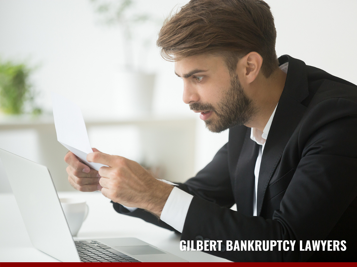 businessman surprised reading a mail being sued by a debt collector