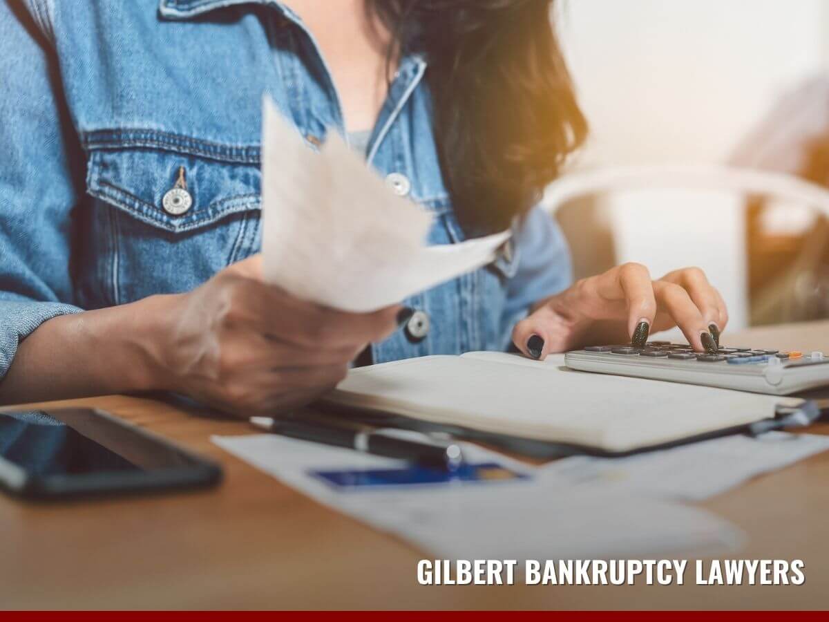 Woman calculating how much debt qualifies her for bankrupcty in Arizona