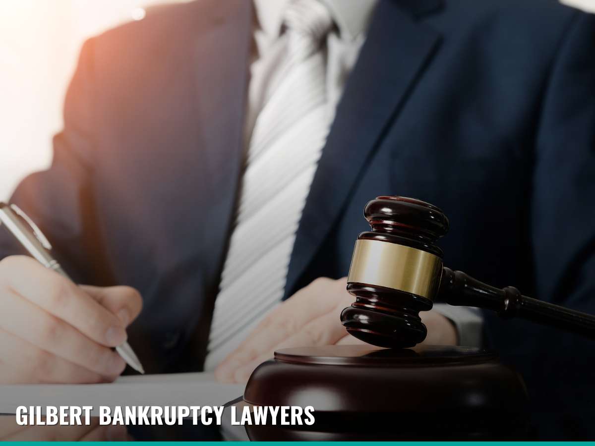 Close-up of a gavel on a table with two professionals discussing in the background, representing Gilbert Bankruptcy Lawyers specializing in bankruptcy exemptions